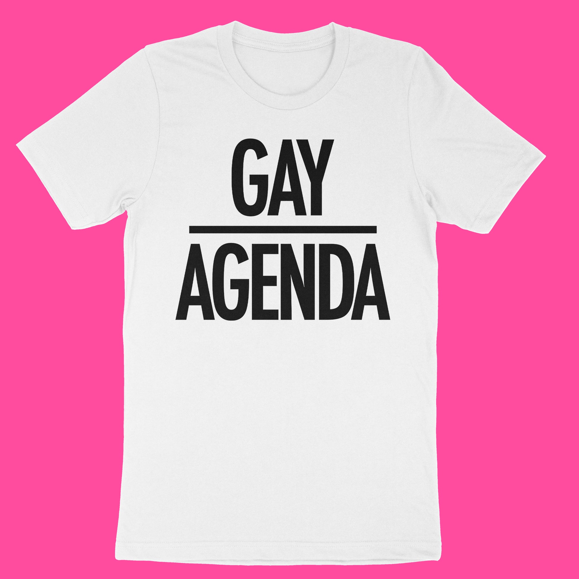 A white short-sleeve crewneck t-shirt with bold black text reading 'GAY AGENDA' separated by a horizontal line, displayed flat against a solid bright pink background.