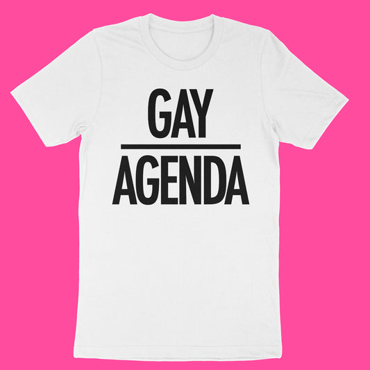 A white short-sleeve crewneck t-shirt with bold black text reading 'GAY AGENDA' separated by a horizontal line, displayed flat against a solid bright pink background.
