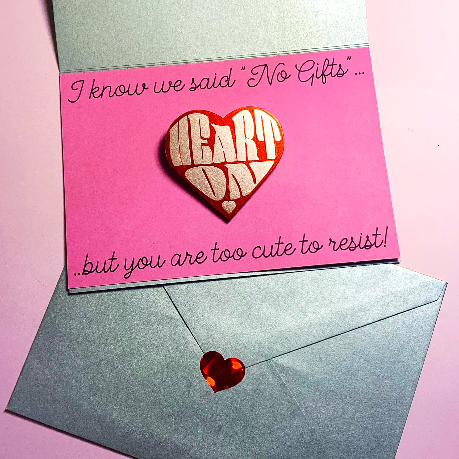 "Heart On" heart-shaped pin - metallic pink & red option, packaged with personal message "I know we said No Gifts, but you are too cute to resist!" machine-written on pink & silver card, envelope set