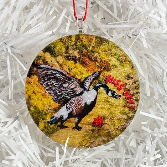 Round handmade glass Christmas ornaments with a Canada goose painting and 'Hiss Off!' text