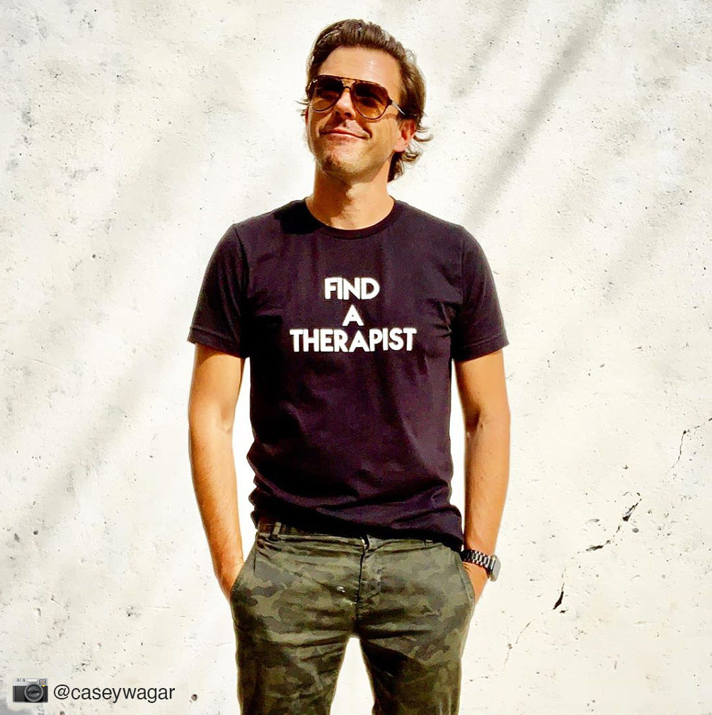 Handsome man wearing black custom text tee reading Find A Therapist by BBJ / Glitter Garage