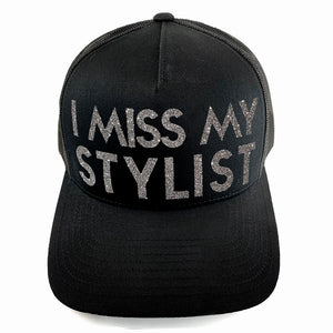 Classic black snapback hat with bold I Miss My Stylist text by BBJ / Glitter Garage. Silver glitter text. Front view.
