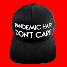 Load image into Gallery viewer, Classic black snapback hat with bold Pandemic Hair Don&#39;t Care white matte text by BBJ / Glitter Garage. Glitter and matte vinyl colour options. Unisex style, breathable mesh back with matching plastic snap closure fits most.
