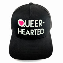 Load image into Gallery viewer, Classic black snapback hat with matte glow-in-the-dark and pink neon “Queer-hearted” detail by BBJ / Glitter Garage. Unisex style, breathable mesh back with matching plastic snap closure fits most. Front view.
