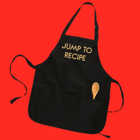 Black baker-style apron with custom text "Jump To Recipe" in gold glitter geometric text