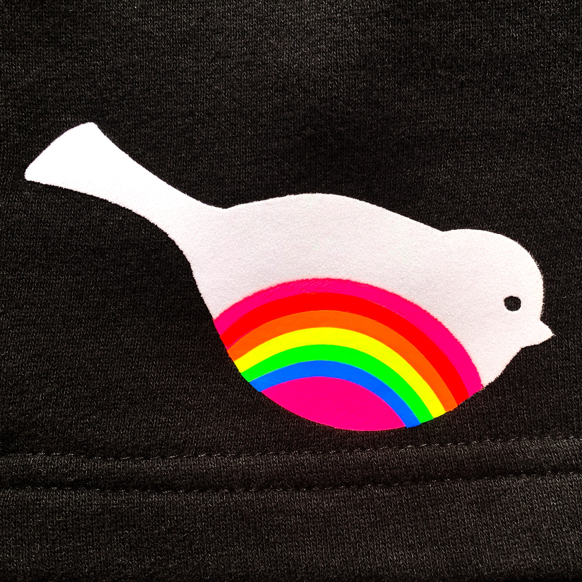 texture detail of fuzzy white flock bird with neon rainbow striped belly on black unisex shorts by BBJ / Glitter Garage